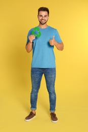 Photo of Young man with recycling symbol on yellow background