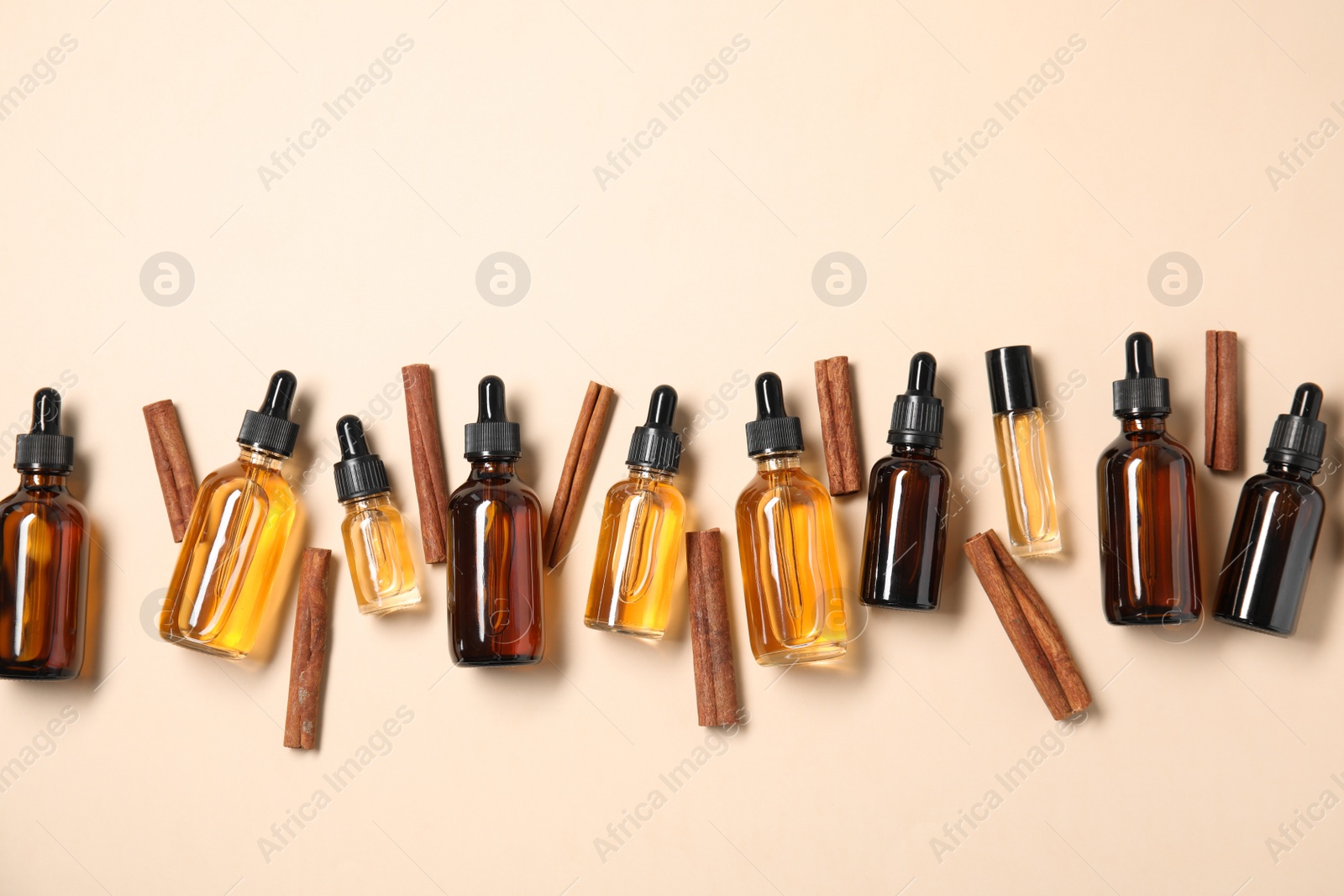 Photo of Flat lay composition with cinnamon essential oil on beige background