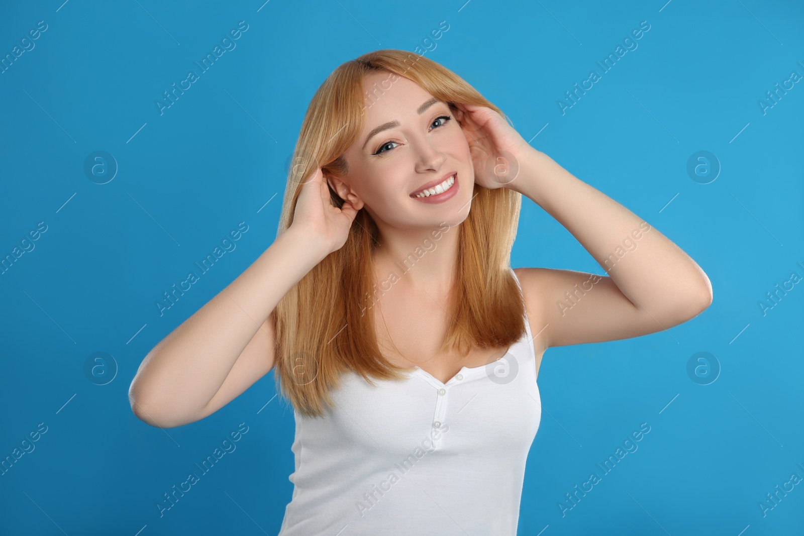 Photo of Beautiful young woman with blonde hair on blue background