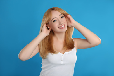 Photo of Beautiful young woman with blonde hair on blue background