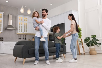 Happy family dancing and having fun at home, low angle view