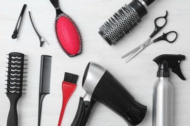 Photo of Flat lay composition with professional hairdresser tools on wooden background