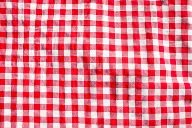 Red checkered picnic tablecloth as background, top view