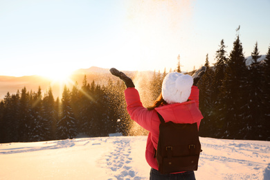 Photo of Young woman having fun outdoors on snowy winter day. Space for text