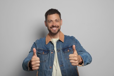 Man showing thumbs up on grey background