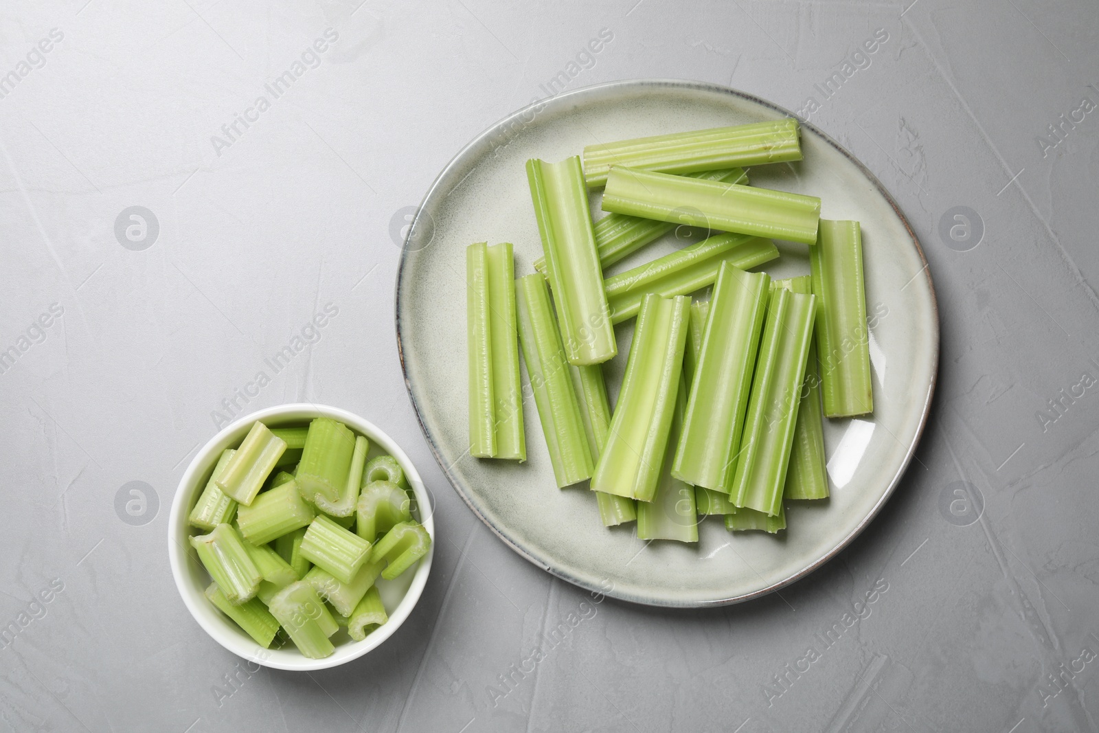 Photo of Fresh green cut celery on light grey table, flat lay