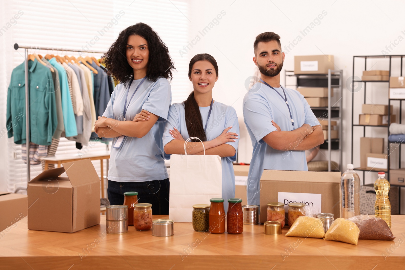 Photo of Portrait of volunteers and food products at table in warehouse