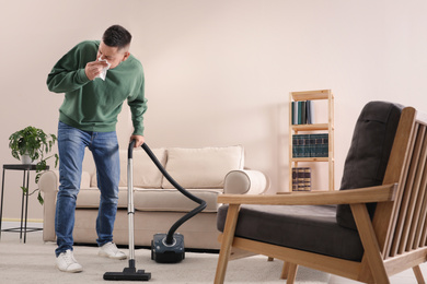 Photo of Man with dust allergy cleaning his home