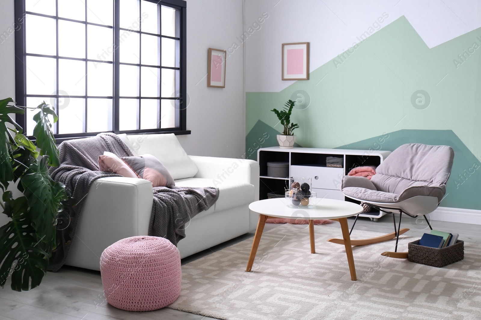 Photo of Stylish living room interior with comfortable sofa and rocking chair