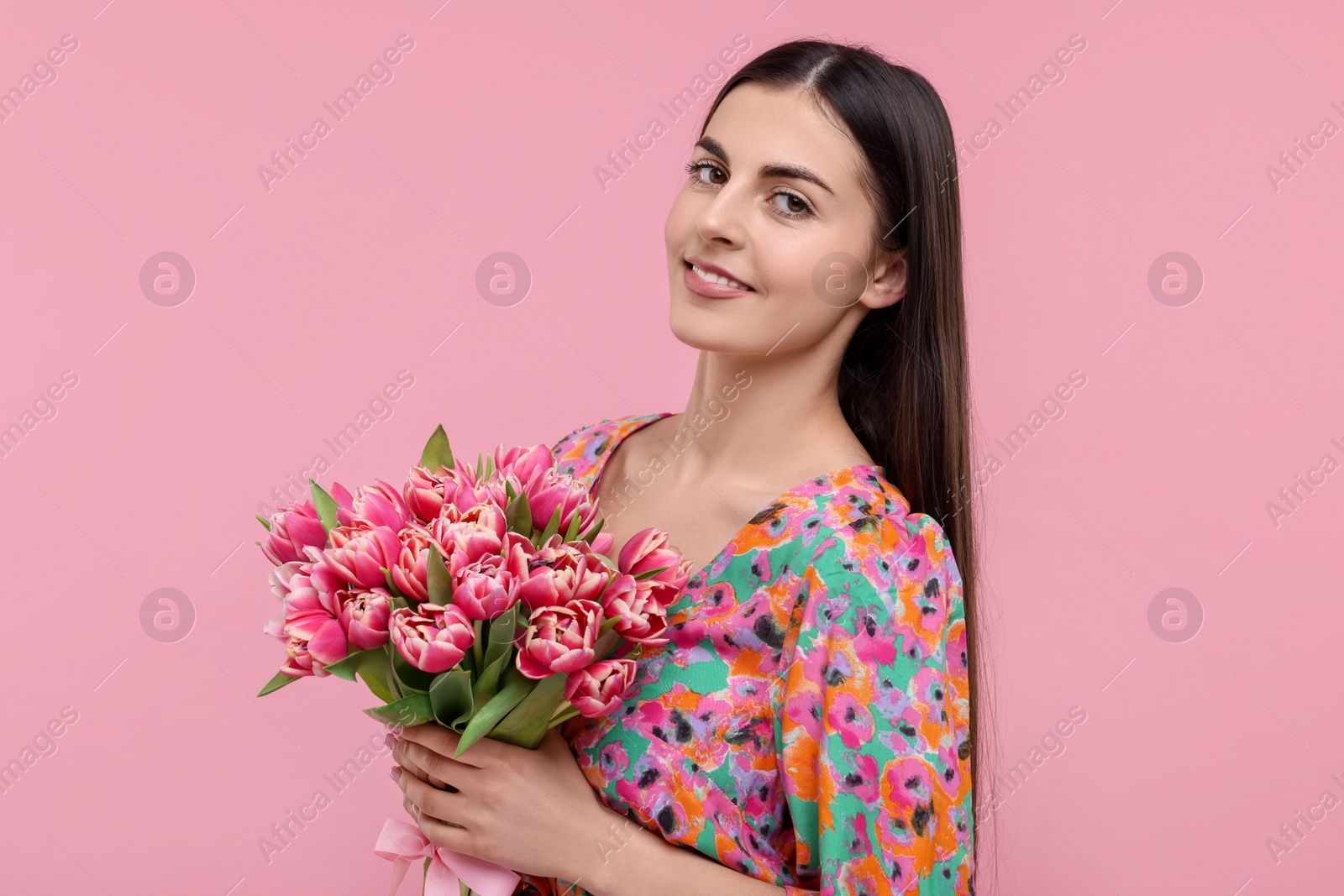 Photo of Happy young woman with beautiful bouquet on dusty pink background