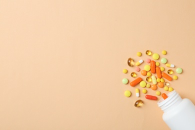 Photo of Bottle, different pills and space for text on color background, top view