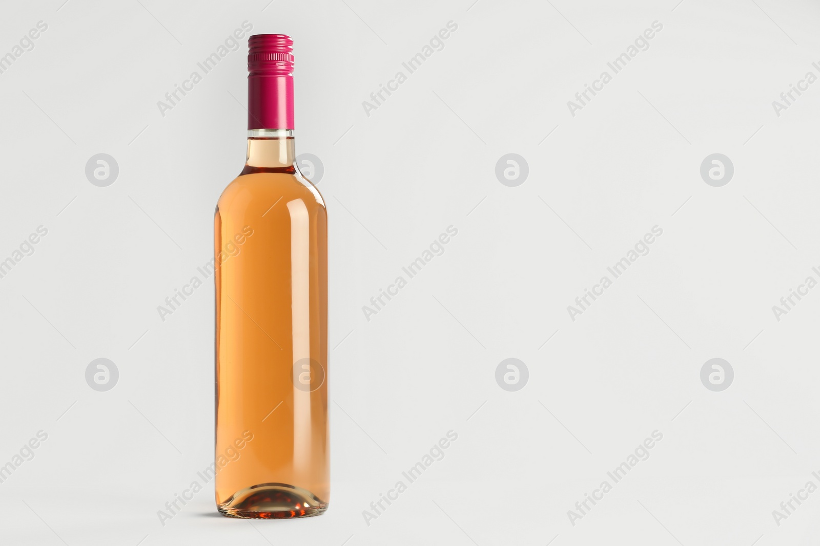 Photo of Bottle of expensive rose wine on light background. Space for text