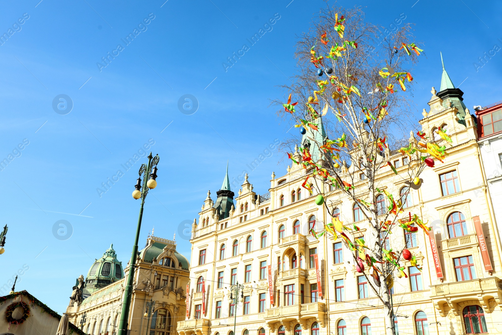 Photo of PRAGUE, CZECH REPUBLIC - APRIL 25, 2019: Decorated Easter tree in front of Hotel Kings Court. Space for text