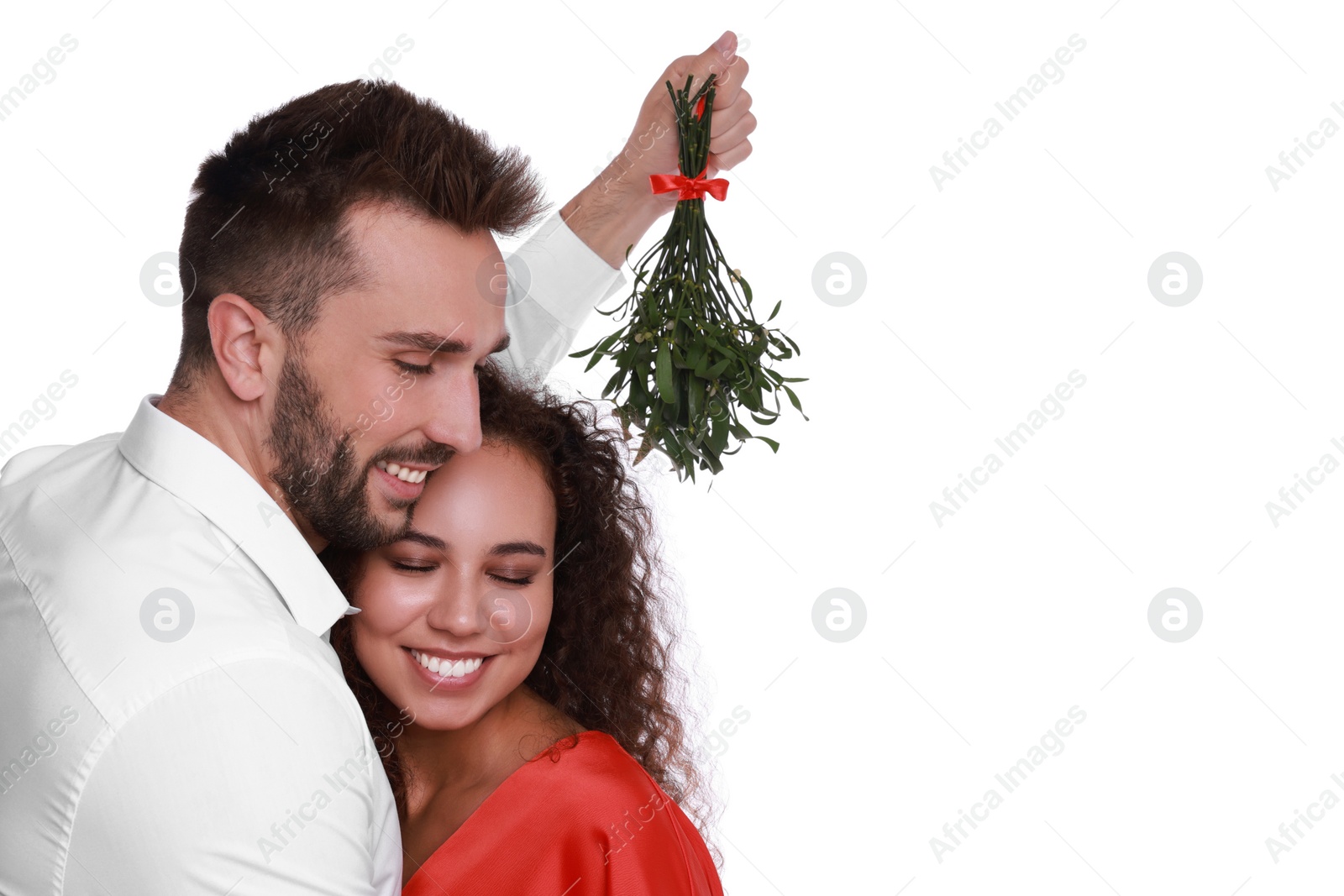 Photo of Lovely couple under mistletoe bunch on white background