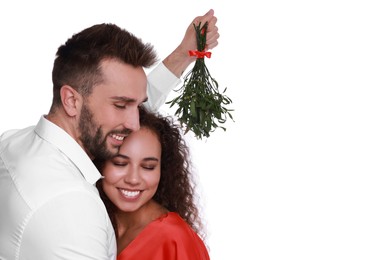Photo of Lovely couple under mistletoe bunch on white background