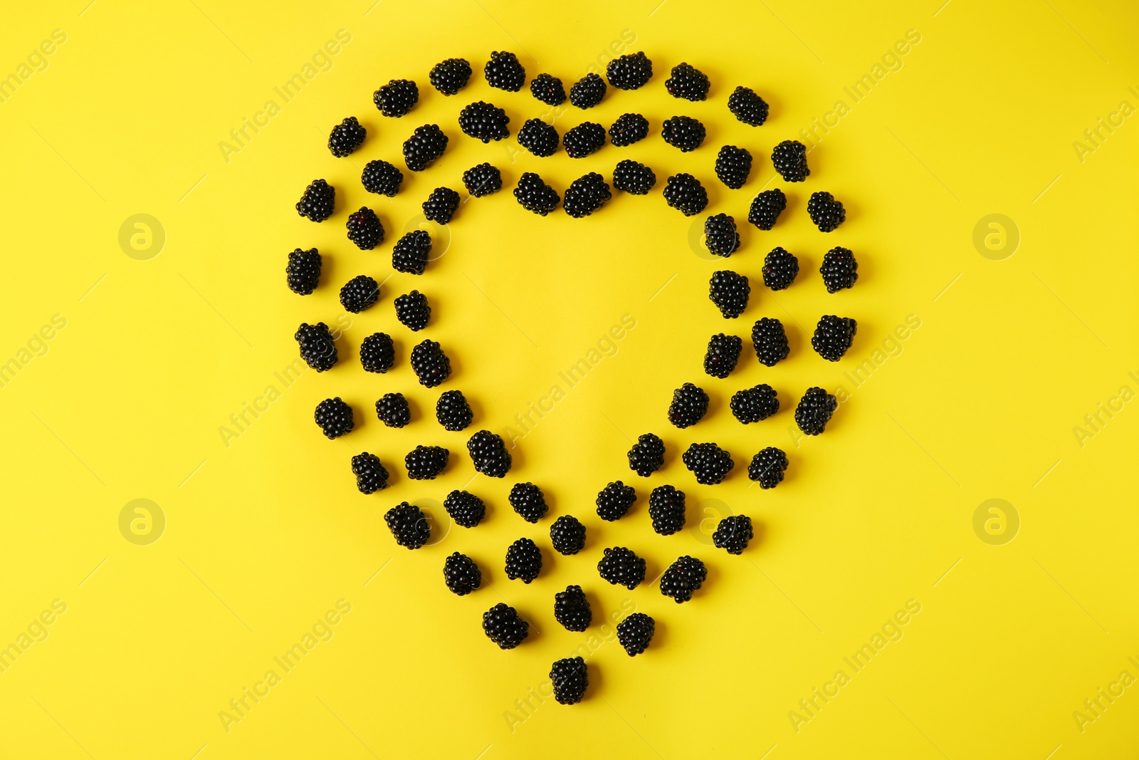 Photo of Flat lay composition with ripe blackberries on yellow background. Space for text