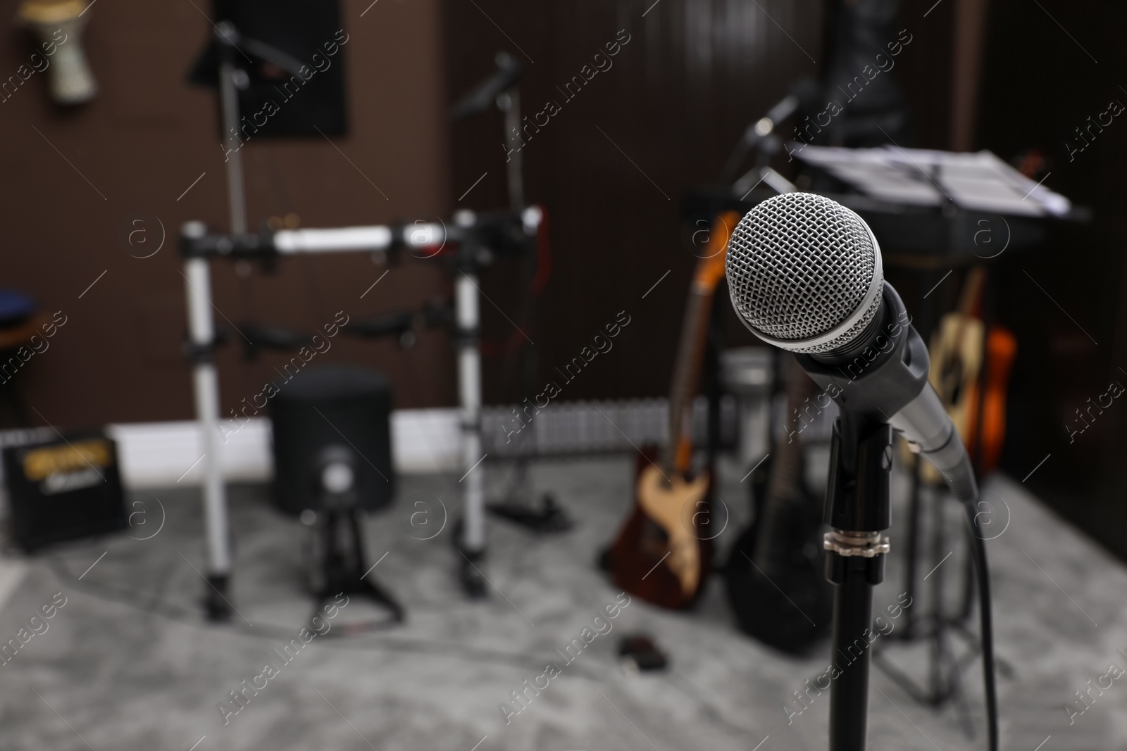 Photo of Modern microphone at recording studio, space for text. Music band practice