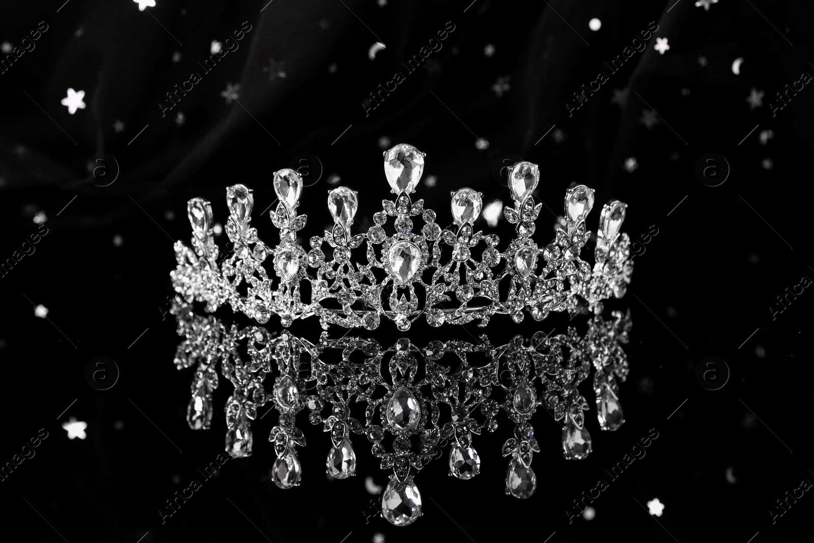 Photo of Beautiful silver tiara with diamonds on dark mirror surface