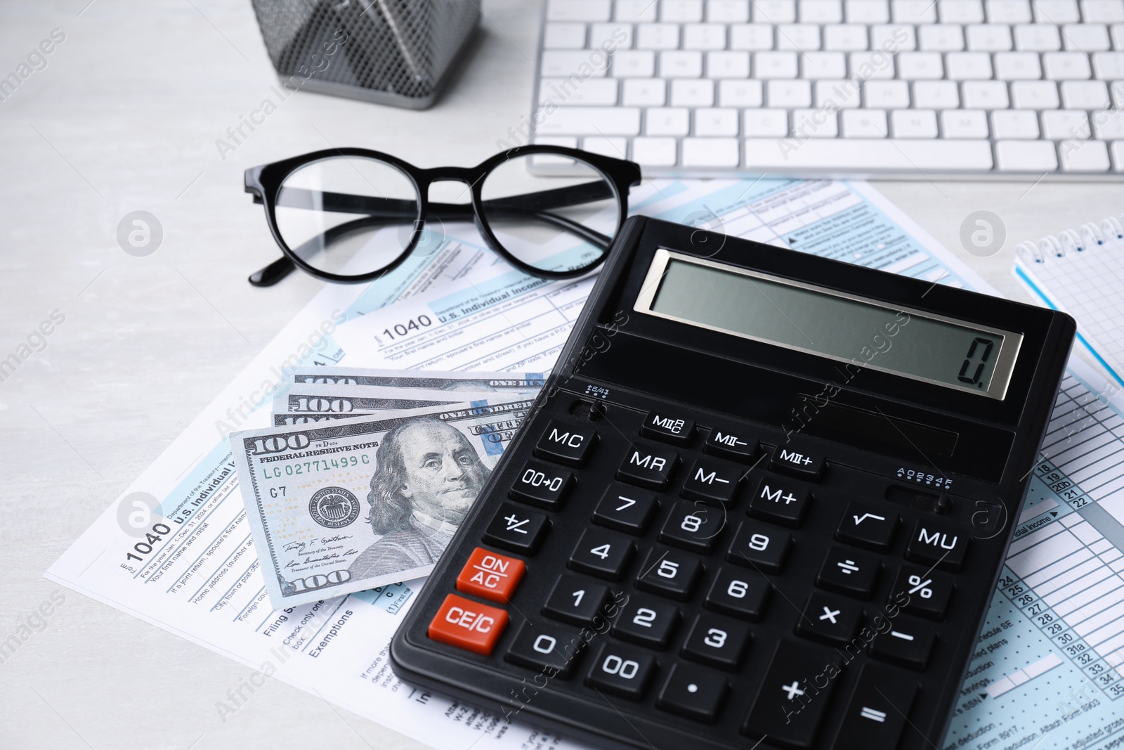 Photo of Tax accounting. Calculator, documents, money and glasses on light grey table