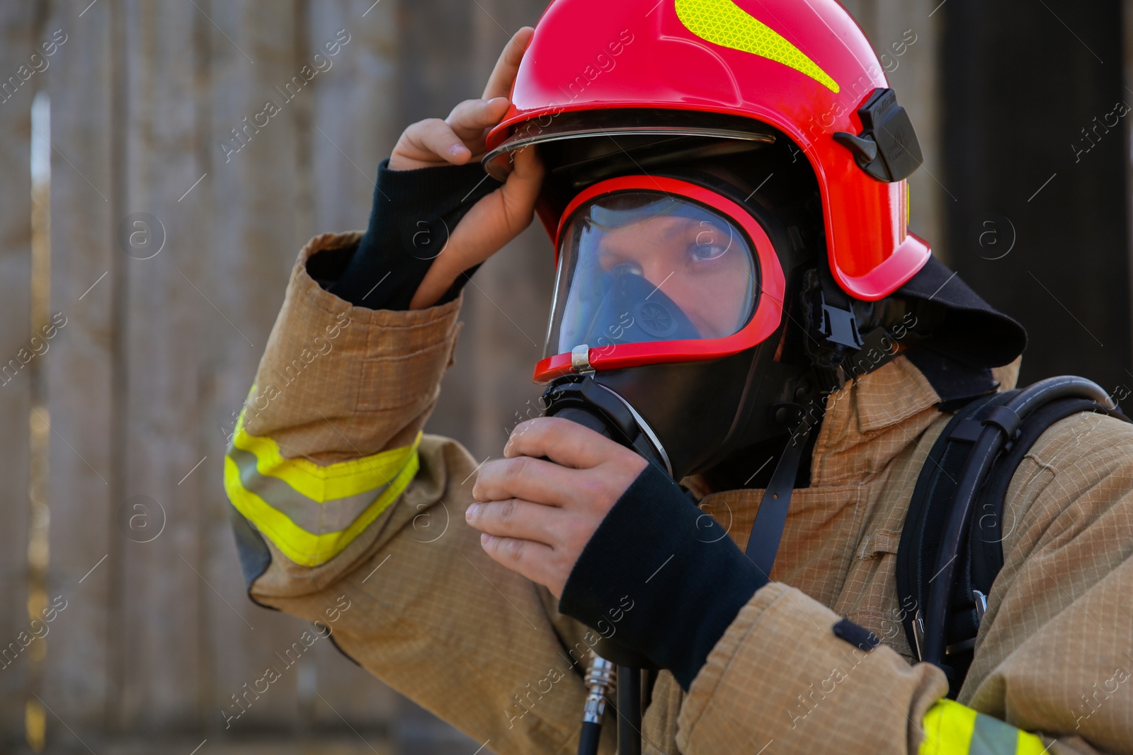 Photo of Firefighter in uniform wearing helmet and mask outdoors