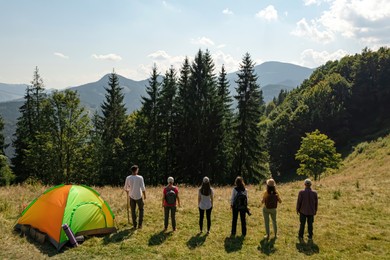 Group of tourists near camping tent in mountains, aerial view. Drone photography