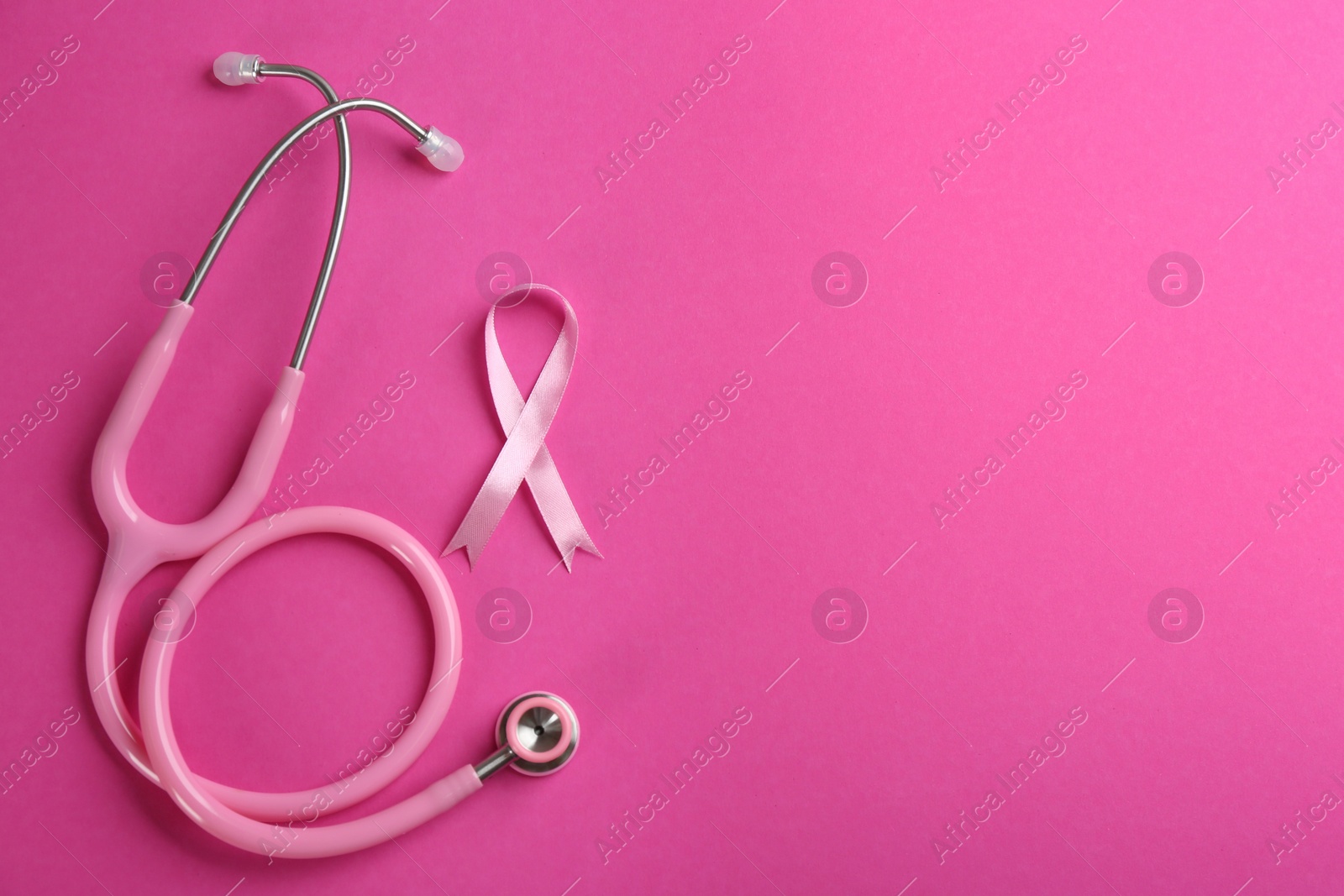 Photo of Pink ribbon and stethoscope on color background, flat lay with space for text. Breast cancer concept