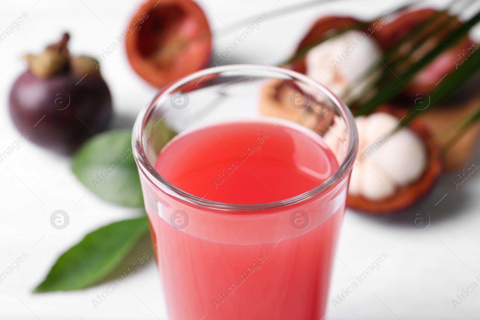 Photo of Delicious fresh mangosteen juice in glass, closeup view