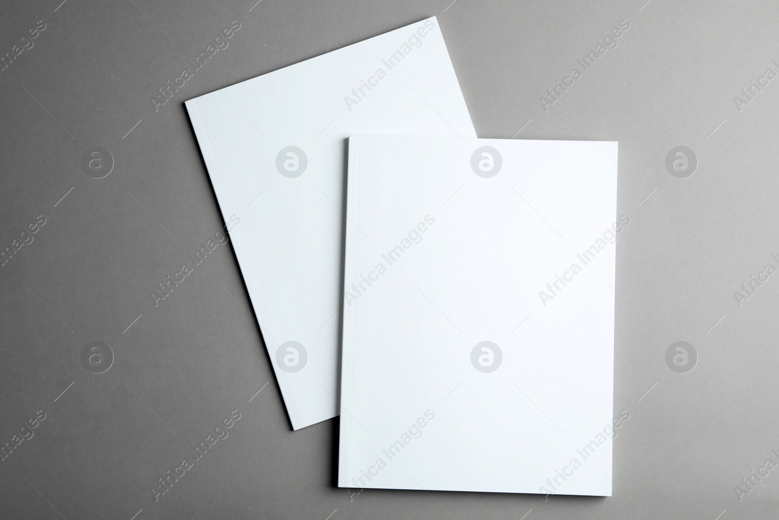 Photo of Brochures with blank covers on grey background, top view. Mock up for design