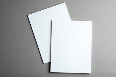 Brochures with blank covers on grey background, top view. Mock up for design