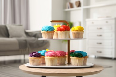 Photo of Delicious cupcakes with bright cream on wooden table indoors