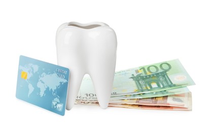 Photo of Ceramic model of tooth, euro banknotes and credit card on white background. Expensive treatment