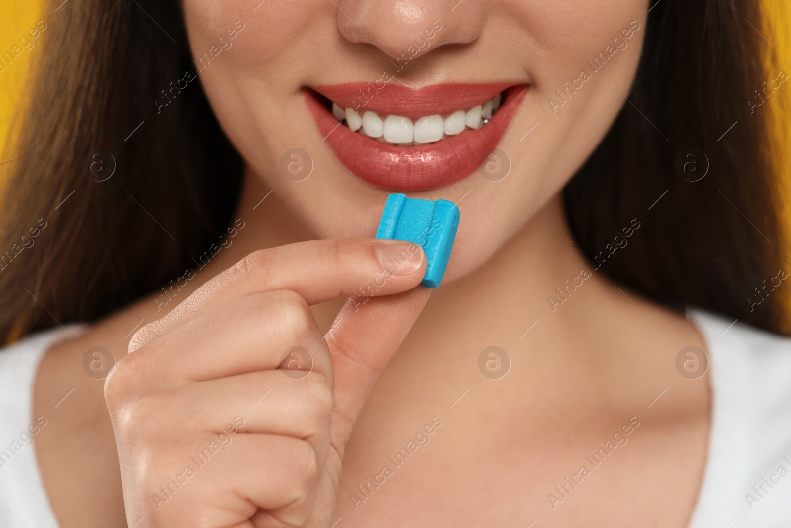 Photo of Woman with bubble gum on yellow background, closeup