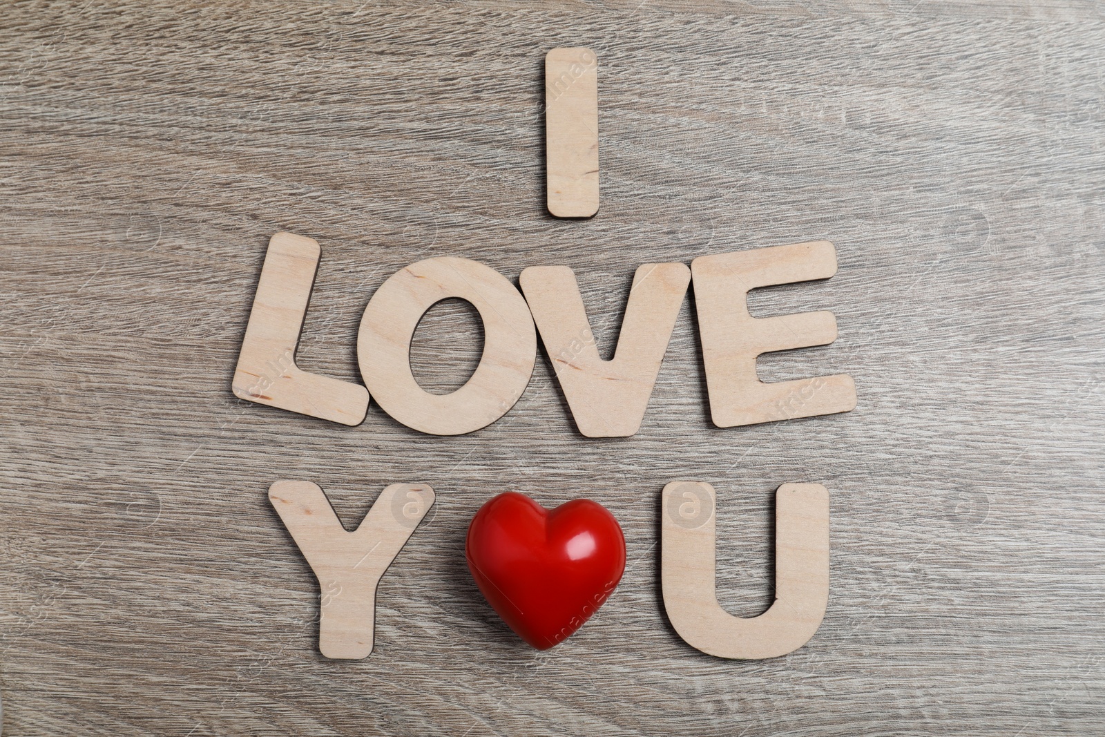 Photo of Phrase I Love You made of decorative heart and letters on wooden background, flat lay