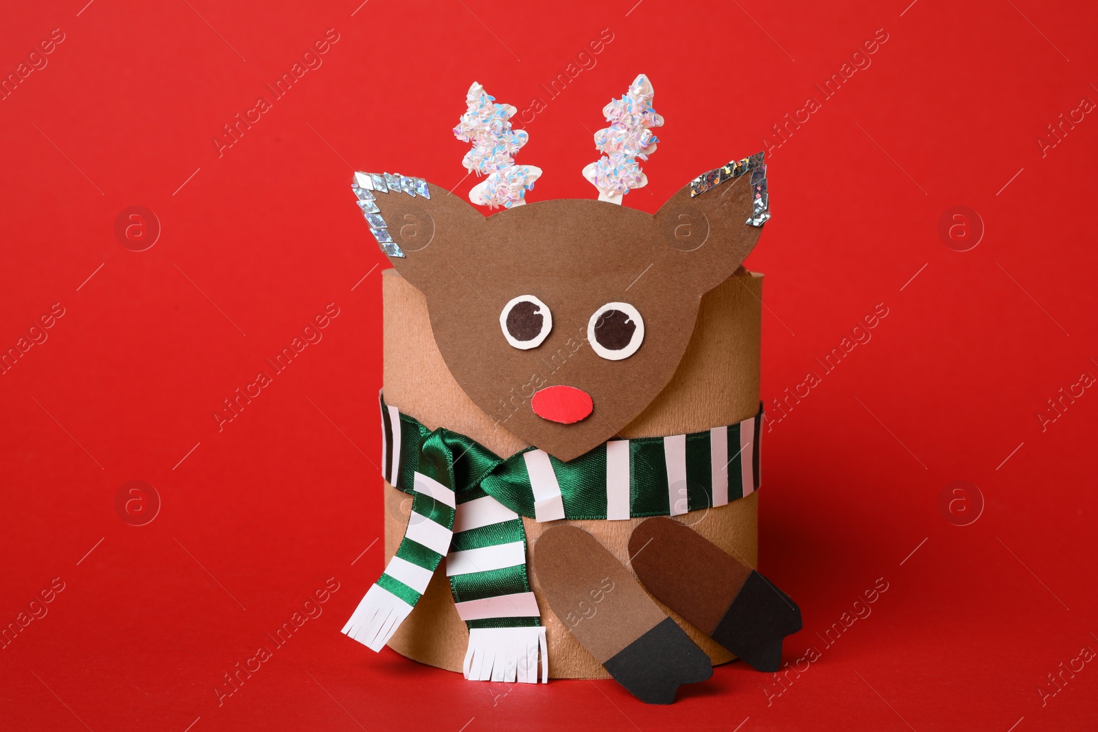 Photo of Toy deer made of toilet paper roll on red background