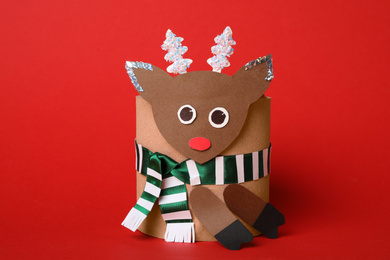 Photo of Toy deer made of toilet paper roll on red background