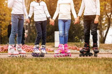 Photo of Children wearing roller skates in autumn park