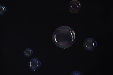 Many beautiful soap bubbles on black background