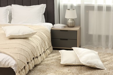 Photo of Soft white pillows on floor in bedroom