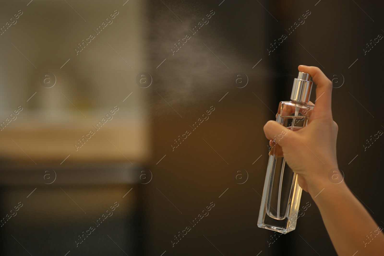 Photo of Woman spraying air freshener at home, closeup. Space for text