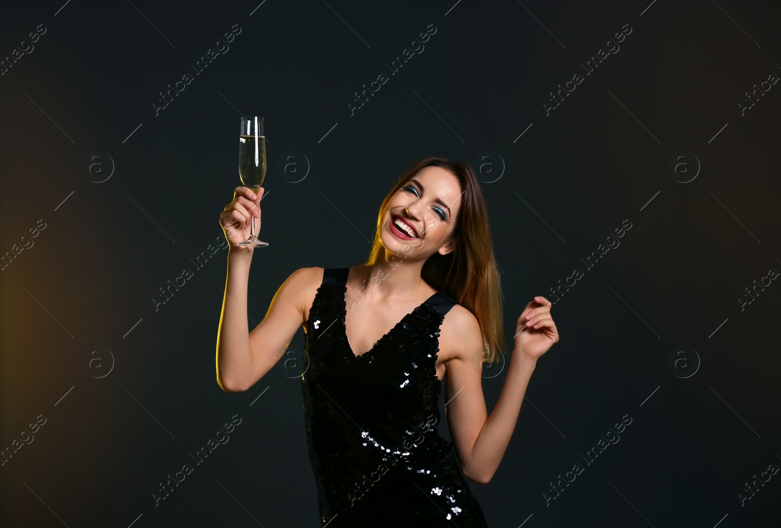 Photo of Portrait of happy woman with champagne in glass on color background