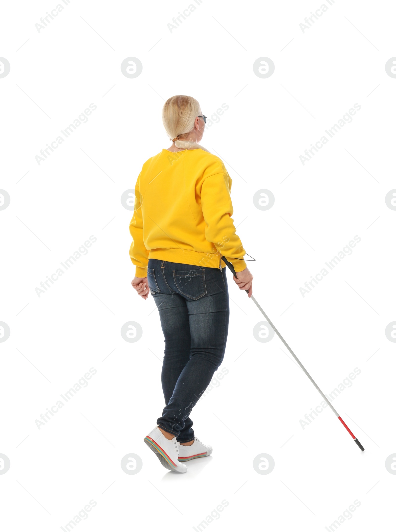 Photo of Mature blind person with long cane walking on white background