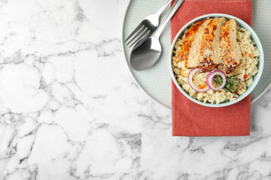 Photo of Delicious chicken risotto served on white marble table, top view. Space for text