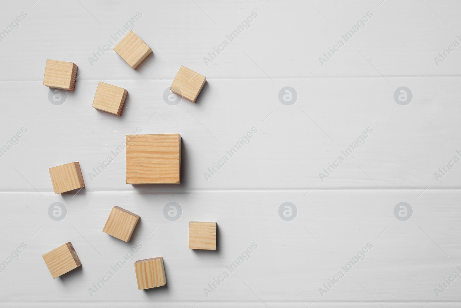 Photo of Blank cubes on white wooden table, flat lay. Space for text