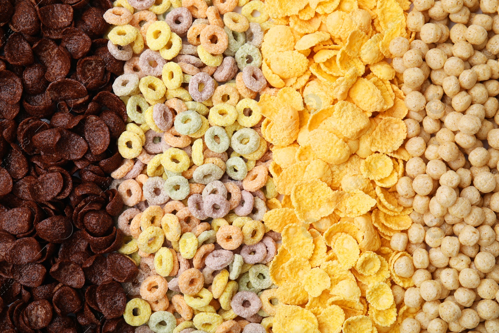 Photo of Different types of breakfast cereals as background, top view