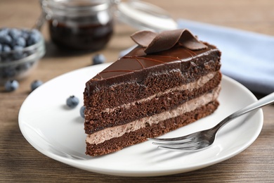 Photo of Delicious fresh chocolate cake served on wooden table