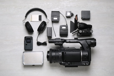 Flat lay composition with camera and video production equipment on light grey background