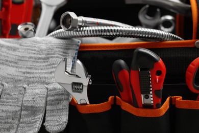 Plumber's bag with different tools, closeup view