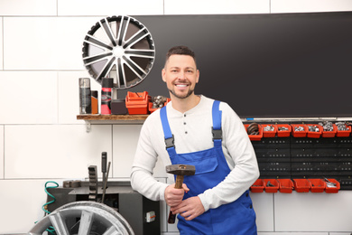 Photo of Mechanic near car disk lathe machine at tire service