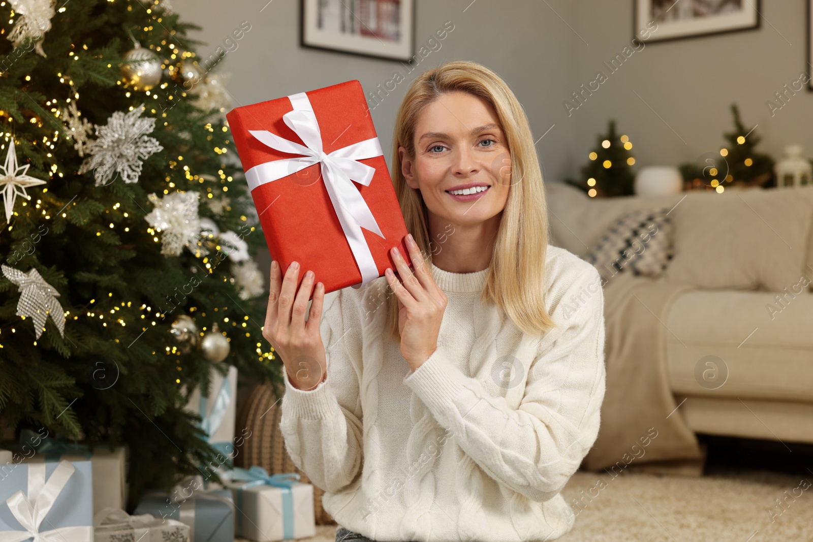 Photo of Happy woman with Christmas gift at home