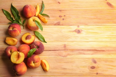 Photo of Fresh sweet peaches on wooden table, flat lay. Space for text